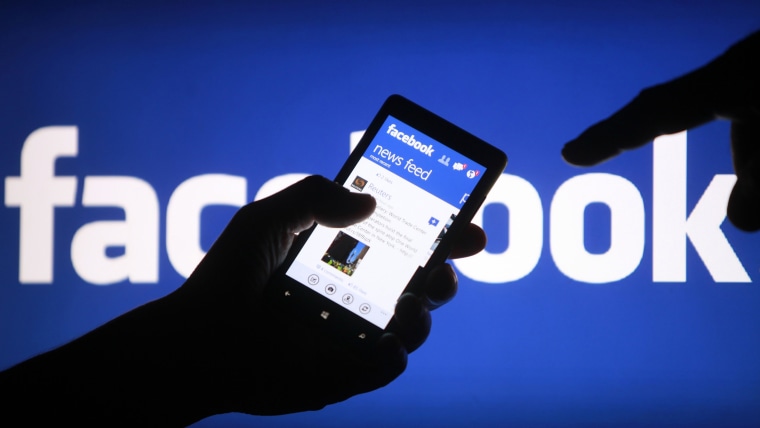 A smartphone user shows the Facebook application on his phone in the central Bosnian town of Zenica, in this file photo illustration from May 2, 2013....