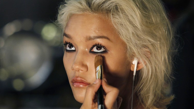 A model has her make-up applied before presenting a creation by DKNY during the Fall 2014 collection at New York Fashion Week February 9, 2014. REUTER...