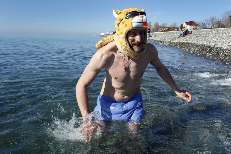 epa04074193 A Russian man swims in the Black Sea outside the Olympic Park at the Sochi 2014 Olympic Games, Sochi, Russia,13 February 2014. Warm weathe...