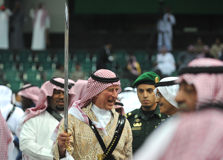 epa04086885 HRH The Prince of Wales, Prince Charles (C), wears a traditional Saudi uniform as he joins in a traditional Saudi sword dance, also known ...