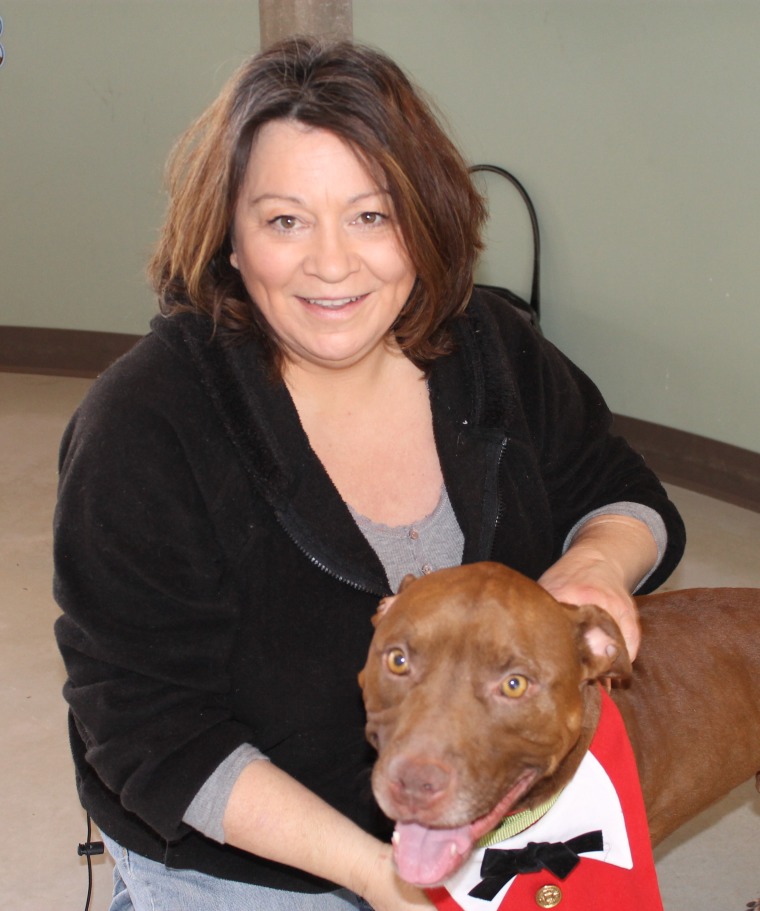 Soldier, a pit bull who was found with a mystery photo tucked inside his collar, is pictured with Julie Hensley, his new owner.