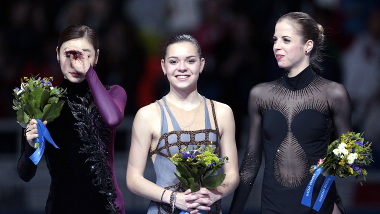 Adelina Sotnikova of Russia, centre, Yuna Kim of South Korea, left, and Carolina Kostner of Italy stand on the podium during the flower ceremony for t...
