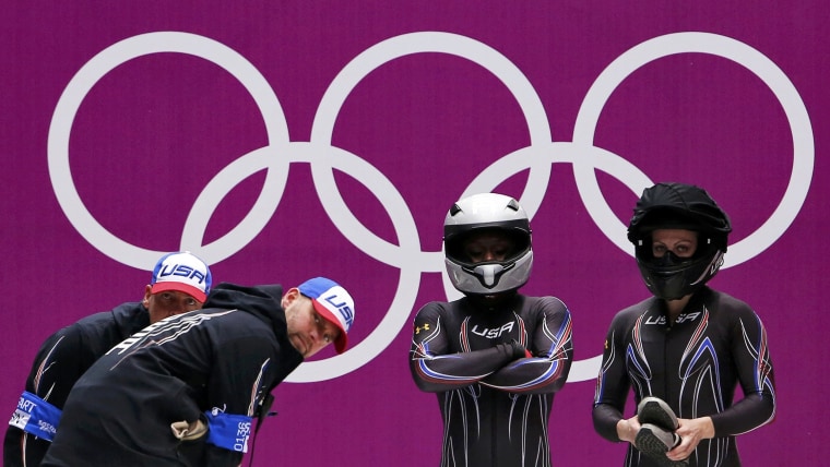 From left, coaches Todd Hayes and Stu McMillan stand with Aja Evans and pilot Jamie Greubel