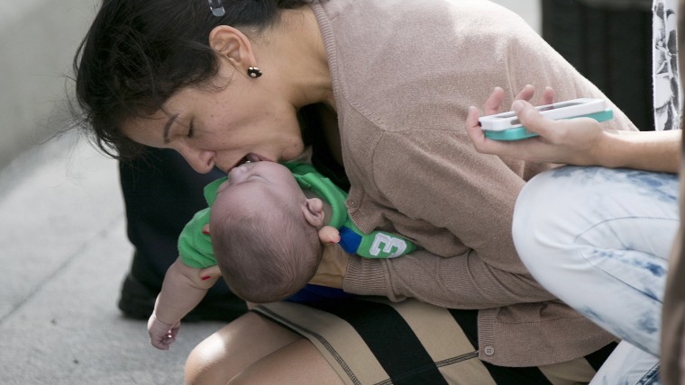 Pamela Rauseo, 37, performs CPR on her nephew, five-month-old Sebastian de la Cruz, after pulling her SUV over on the side of the road along the west ...