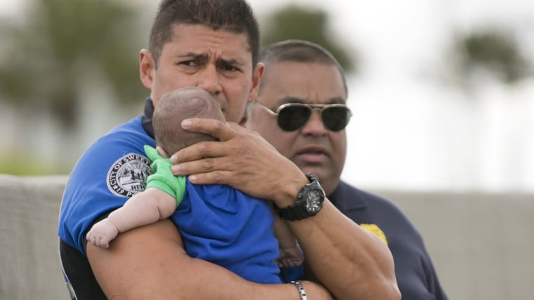 Sweetwater officer Amauris Bastidas keeps a watchful eye waiting for paramedics after aiding a five-month-old Sebastian de la Cruz who stopped breathi...
