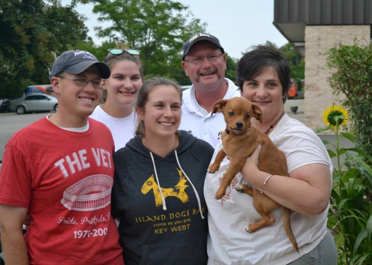 Frank the dog with his foster family and his adoptive family. He was taken home on Aug. 16, 2013.