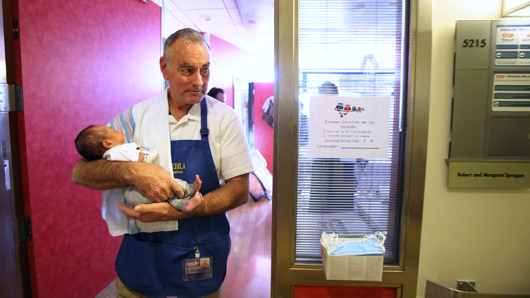 LOS ANGELES, CA - DECEMBER 11, 2013:  Volunteer Jim O'Connor walks around the hospital with month-old patient Mace De Luna at Children's Hospital Dece...