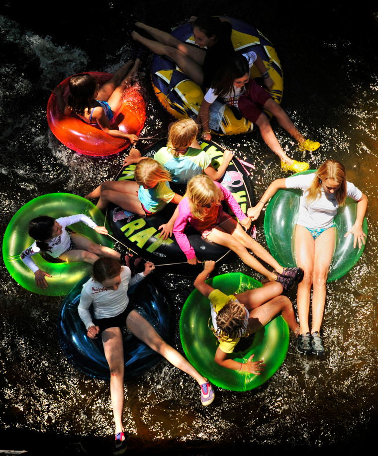 Summer might seem far off, but now's the time that parents start signing up their kids for camp. Girls from Nancy's Summer Camp in Boulder, Colo., hold onto each other as they float down Boulder Creek.