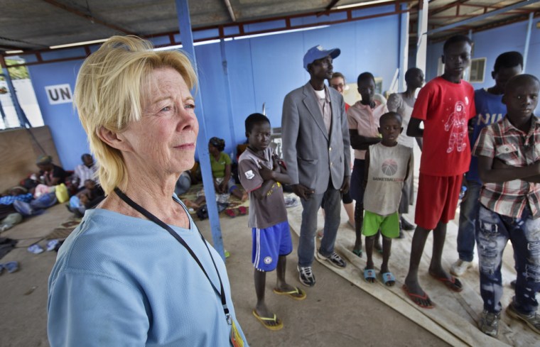 Kim Campbell from Nebraska stands in a United Nations camp Monday with some of the 10 orphan children she and her husband Brad are raising in Malakal, South Sudan.
