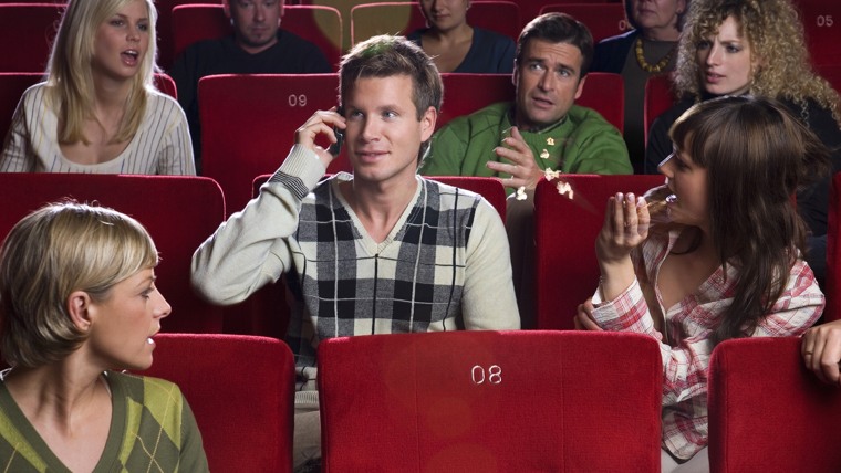 IMAGE: Man talking on cell phone in movie theater
