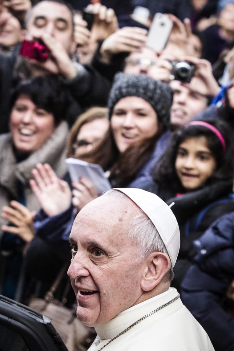 Onlookers applaud as Pope Francis emerges from the door of the Jesus church in Rome, Jan. 3, 2014.