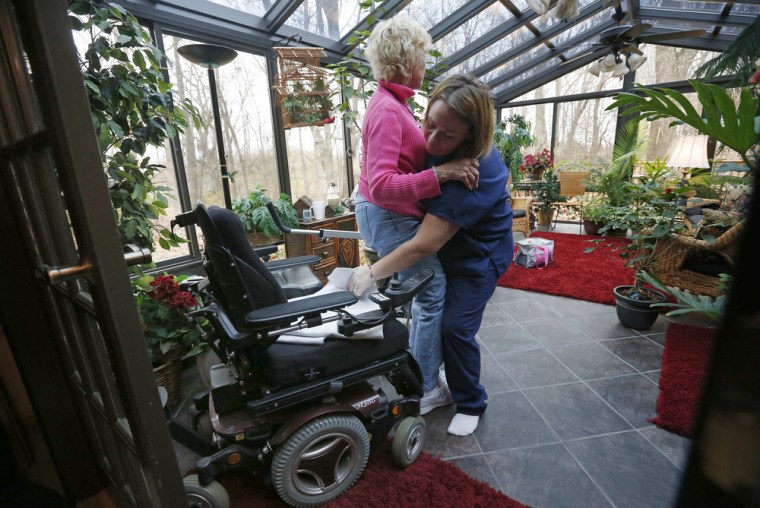 Sandy Wright gets some help from her Certified Nursing Assistant Jessica Haynes at her home in Peoria, Illinois