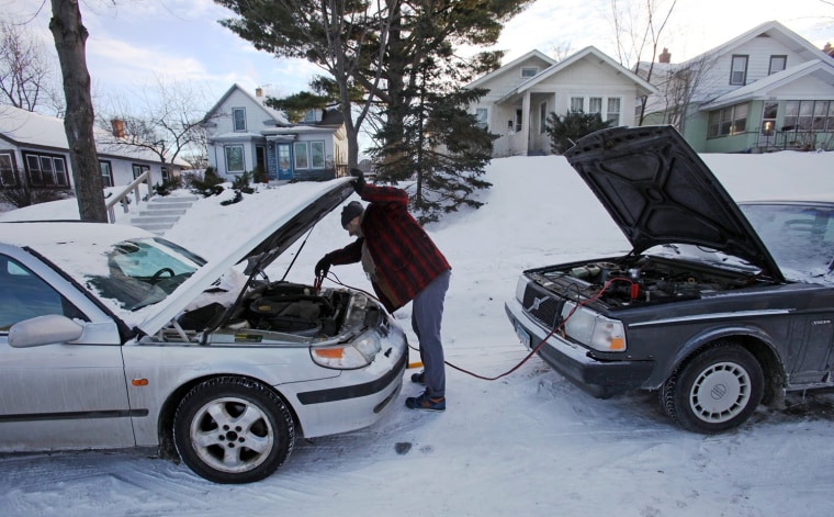 James Diers unhooks jumper cables after he was unable to jump start his car in Minneapolis, Jan. 7, 2014. The Arctic air that has gripped much of the country could cost us $5 billion.