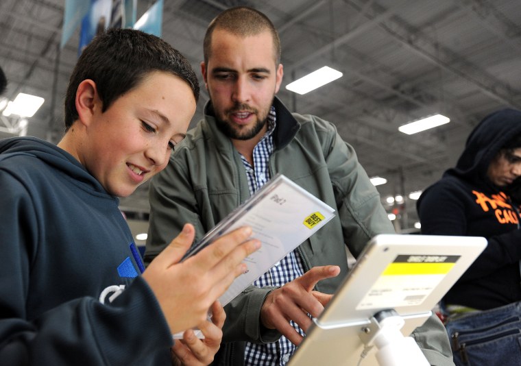 Sabastian Valenzuela, left, and his older brother Alberto compare prices for iPad tablets at a Best Buy on Thanksgiving evening. Best Buy got a shout out from Deal News for making Black Friday deals available a few days before Thanksgiving and matching some of the hottest offers from other retailers.