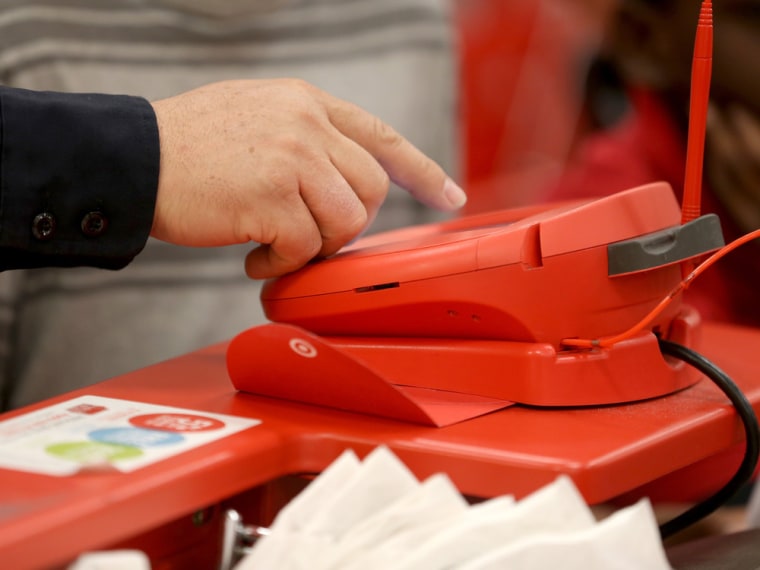 A customer uses a credit card scanner at a Target store. The retailer revealed Friday that the data breach that hit its customers over the heart of the holiday shopping season was almost twice as large as first revealed.