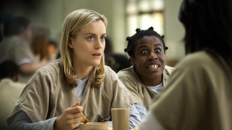 This image released by Netflix shows Taylor Schilling, left, and Uzo Aduba in a scene from \"Orange is the New Black.\"  Revealing secret endings and pl...
