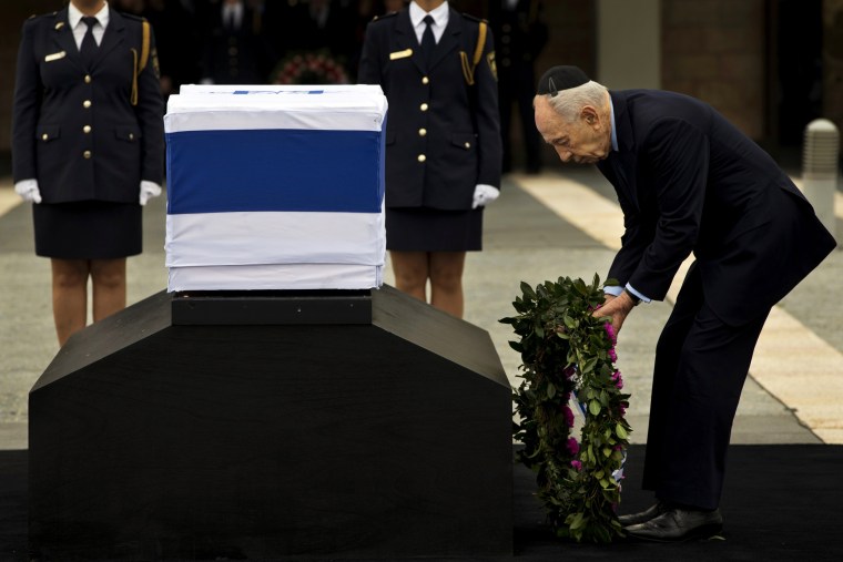 Israel's President Shimon Peres lays a wreath next the coffin of late Israeli Prime Minister Ariel Sharon at the Knesset Plaza, Israeli Parliament, in Jerusalem on Sunday.