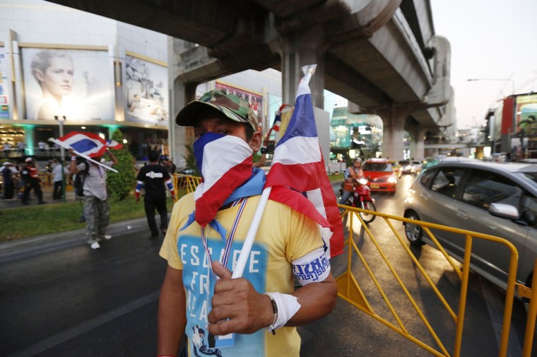 An anti-government protester mans barricade across a major intersection in central Bangkok as part of efforts to force the resignation of Thai Prime Minister Yingluck Shinawatra on Monday, Jan. 12, 2014.