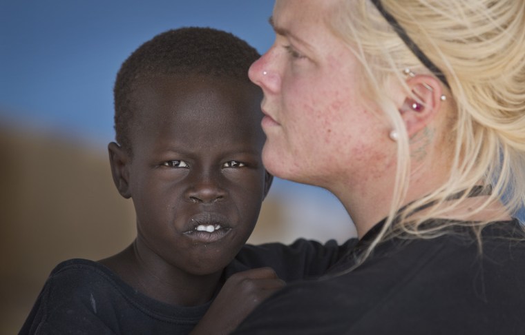 Katie Talbott at at United Nations camp on Dec. 30 holding one of the orphans her mother Kim Campbell and stepfather Brad Campbell are raising in South Sudan.