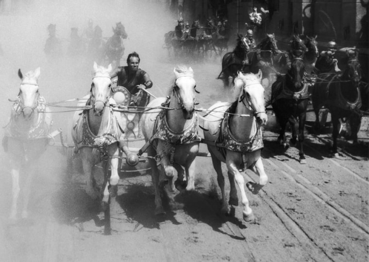 1959:  American actor Charlton Heston competes in a chariot race in a still from the film, 'Ben Hur,' directed by William Wyler.  (Photo by MGM Studio...