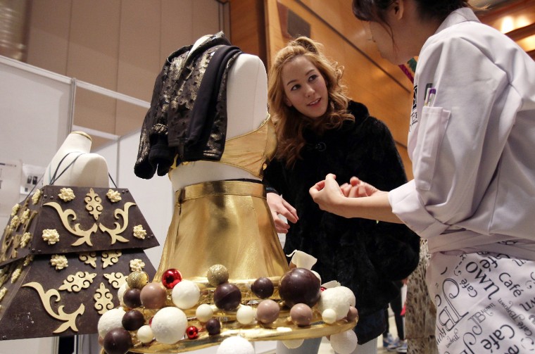An attendee of the Chocolate Fashion Show gets a closer look at the chocolate dresses.