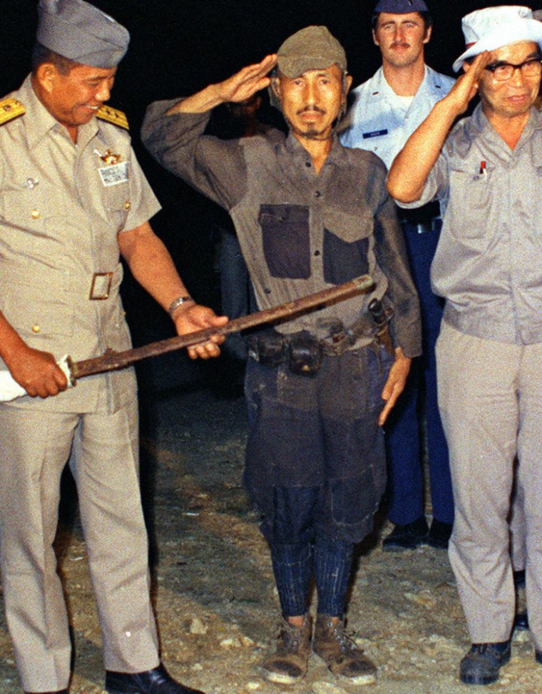 Hiroo Onoda salutes after handing over a military sword and surrendering on the Philippine island of Lubang in 1974.