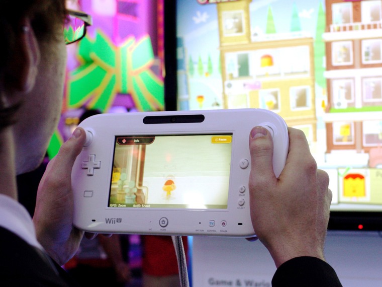 An E3 attendee plays with a Wii U GamePad at Nintendo's booth. In this game, Game & Wario, it is used as a way to zoom in on certain portions of the s...