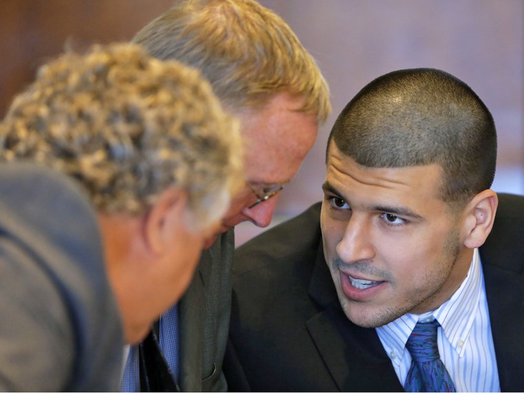 Aaron Hernandez, formerly of the New England Patriots, talks to defense attorneys Michael Fee, left, and Charles Rankin during a court appearance in Fall River, Mass., on Wednesday.