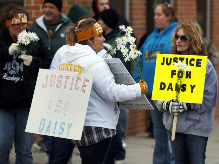 Supporters of Justice for Daisy pass out flowers before a rally Tuesday at the Nodaway County Courthouse in Maryville, Mo.