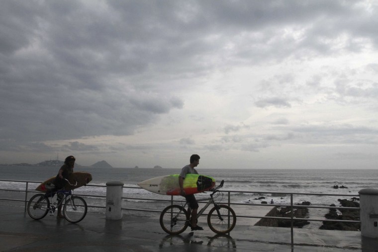 Surfers arrive at El Camaron beach before paddling out into the surf generated by Tropical Storm Sonia in Mazatlan, in the Mexican state of Sinaloa, on Nov. 3.
