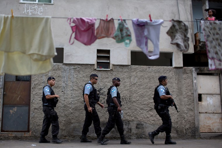 Policemen from the Pacifying Police Unit, or 'UPP', patrol in the Varginha area of the Manguinhos slum complex where Pope Francis will visit next week during his trip to Rio de Janeiro, Brazil.