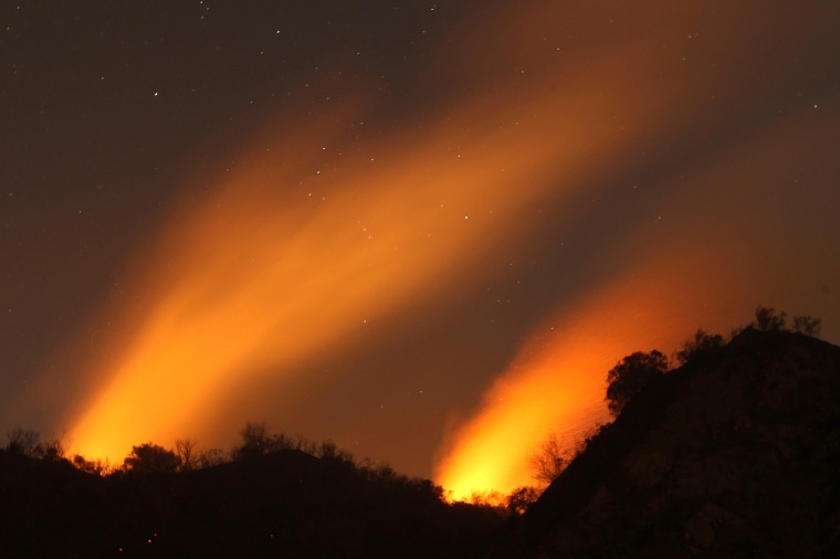 Smoke rises under a starry sky at the Colby Fire in Glendora, California, January 17, 2014.