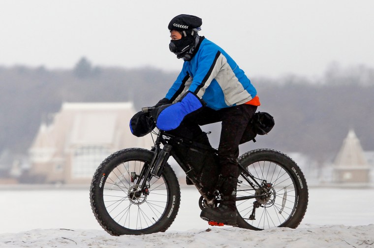 Steve Tannen wears heavy clothing to protect himself against freezing wind chills as he practices for an upcoming bike race in northern Minnesota near...