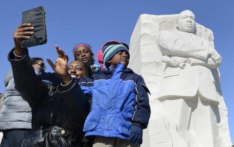 A family takes a self portrait of themselves at the Martin Luther King Memorial in Washington, D.C., on Jan. 19, 2014.