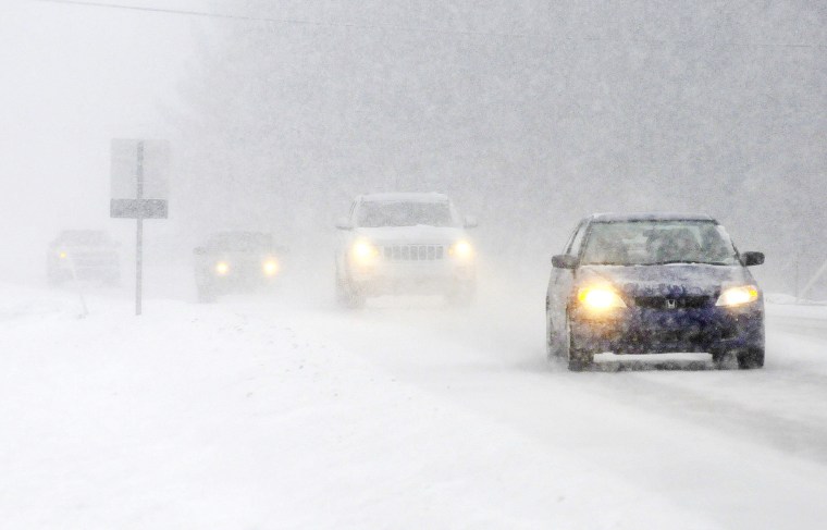 Heavy snow reduces visibility on Indiana 32 in Edgewood Ind. during a snow storm on Saturday Jan. 18, 2014. (AP Photo/The Herald Bulletin, Don Knight)