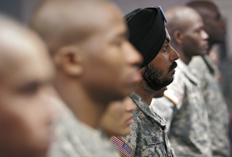 U.S. Army Spc. Simran Lamba, center, the first enlisted Soldier to be granted a religious accommodation for his Sikh articles of faith since 1984, stands in formation with fellow soldiers before taking the oath of citizenship, prior to his graduation from basic training at Fort Jackson, S.C., in 2010.