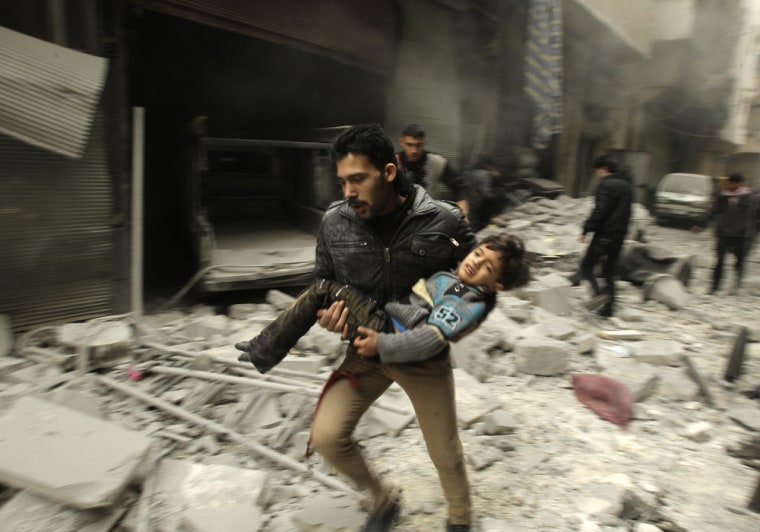 A man runs as he carries a child who survived from what activists say was an airstrike by forces loyal to Syrian President Bashar Assad, at al-Ferdaws in Aleppo on Tuesday.