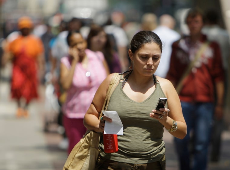 Yvette M. uses her cell phone to text message friends while walking in downtown street, Tuesday, July, 29, 2008, in Chicago. In an alert issued this w...