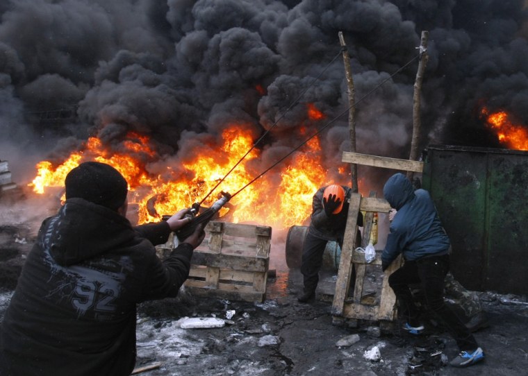Protesters use a large slingshot to hurl rocks at police in central Kiev on Thursday.