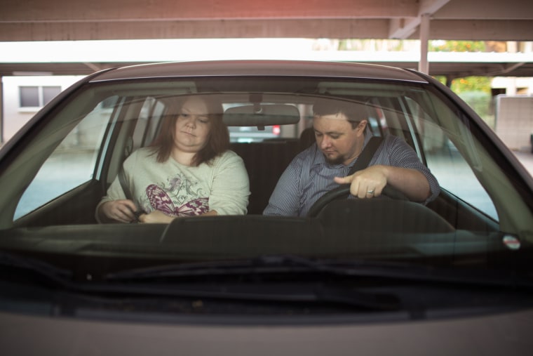 Ben and Erika Trowell leave home for work in the car they share in Phoenix, Ariz.