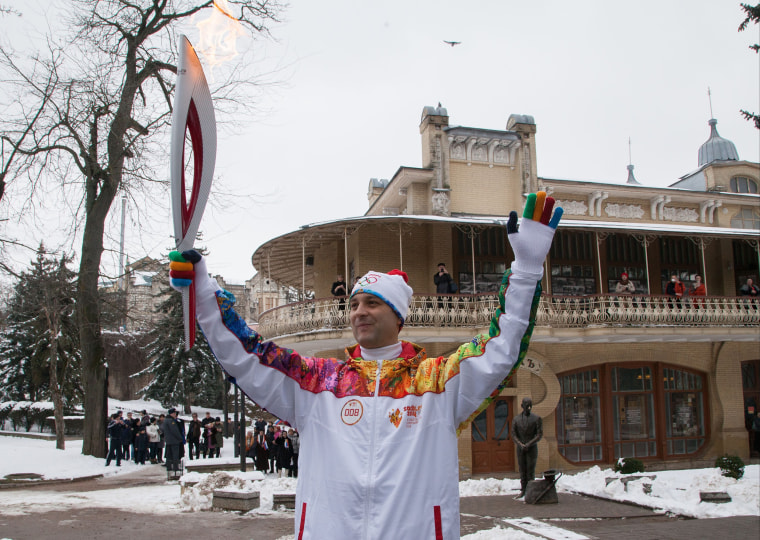 Torch bearer Andrei Yurgin poses with an Olympic torch during the Olympic torch relay in Pyatigorsk, a city in Russia's North Caucasus, on Jan. 23.