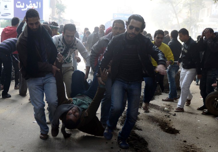 Supporters of the Muslim Brotherhood and ousted Egyptian President Mohammed Morsi carry an injured demonstrator who was shot during clashes in Cairo, Jan. 25, 2014.