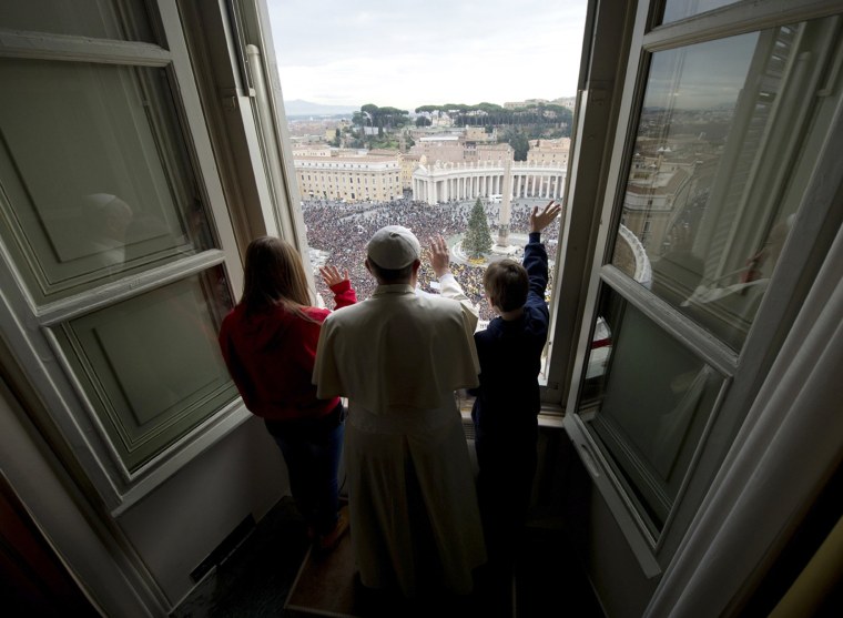 Pope Francis waves with children after he delivered the Angelus prayer at the Vatican on Jan. 26, 2014.