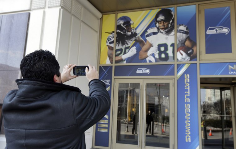 Football fan Raul Moreno of Jersey City, N.J., stops to take a picture of the entrance to the Seattle Seahawks team hotel on Monday in Jersey City, N.J.