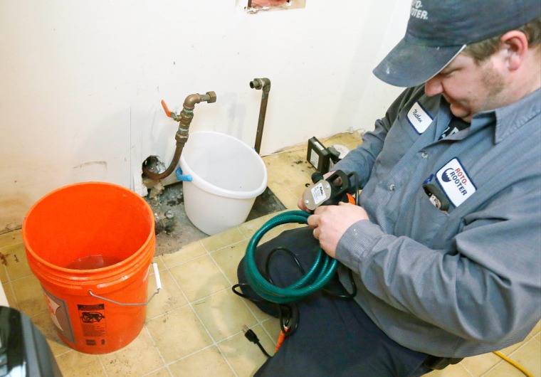 Plumber Nate Petersen prepares a pump to shoot water into the incoming city water line, left pipe, that has been frozen at a south Minneapolis home. Roto Rooter was been inundated with calls since the cold snap and regular work has been put on hold because of burst pipes and even frozen sewer lines, according to plumbing manager Paul Teale.