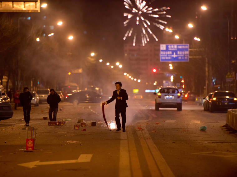 A man runs with fire crackers in China's capital Beijing last year. Fireworks could be banned this year because of smog, officials have warned.