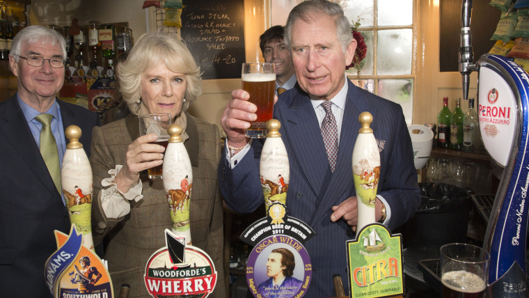 Camilla, Duchess of Cornwall and Prince Charles, Prince of Wales drink beer during a visit to \"The Bell\" pub during an official visit to Essex on January 29.