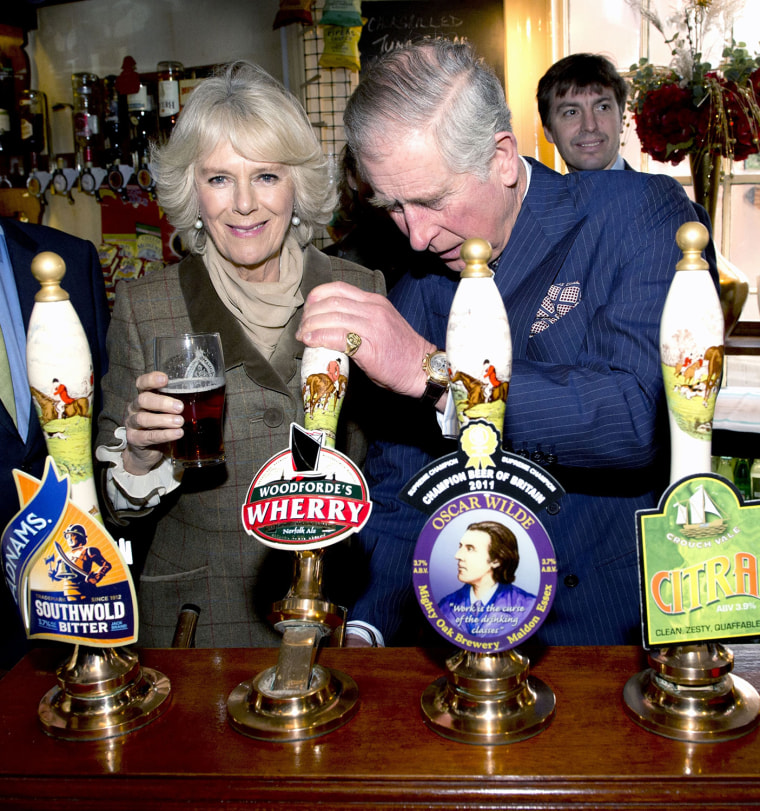 Prince Charles pulls a pint of draught beer as Camilla, The Duchess of Cornwall looks on during a visit to The Bell pub in Purleigh on Jan. 29.