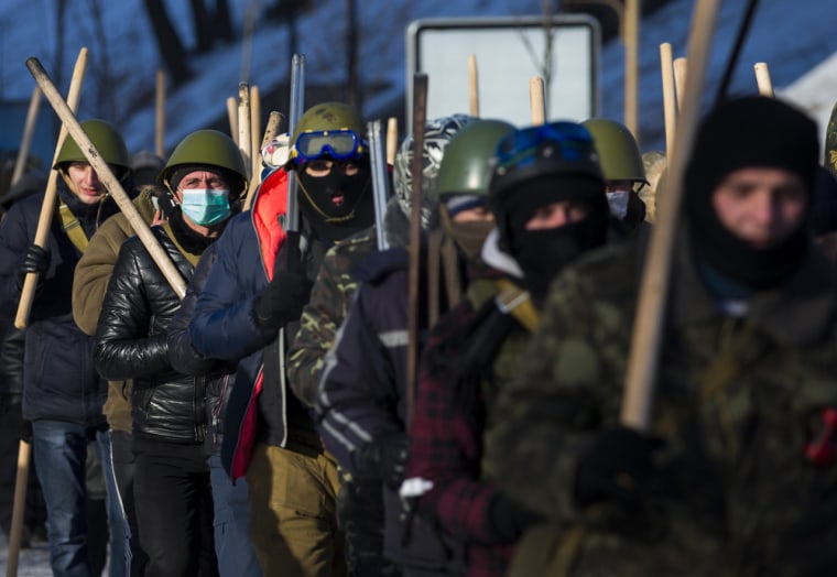 Members of various anti-government paramilitary groups march along a street during a show of force in Kiev on Jan. 29, 2014.