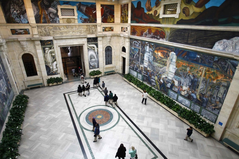People look at a mural by artist Diego Rivera at the Art Institute of Detroit in December. Some of the art collection owned by the city of Detroit is in jeopardy of being auctioned off due to the city's bankruptcy. To keep the art from potential sale, a coalition of foundations and individuals has pledged $370 million to go toward pension benefits for retirees.